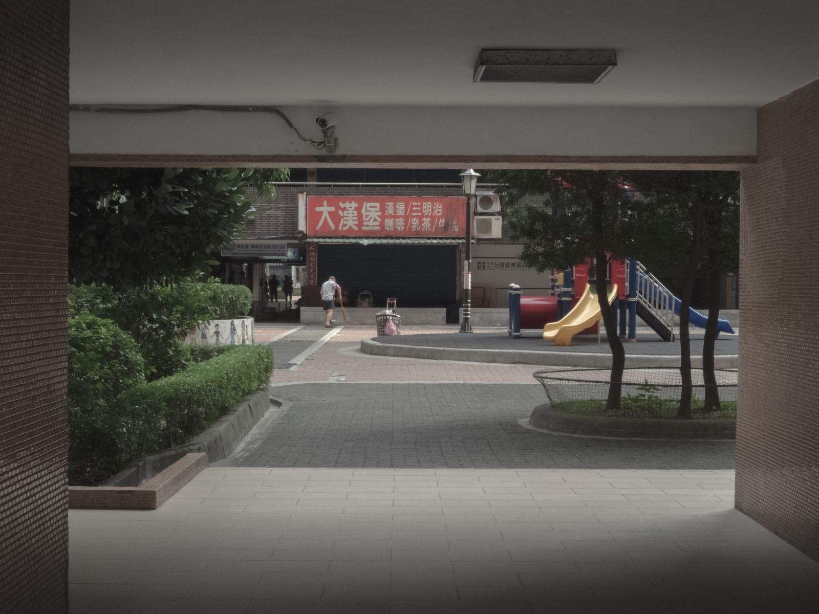 幕 從暗處望向明亮的社區廣場與兒童溜滑梯