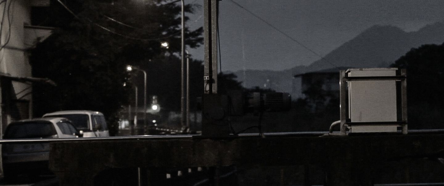 流 夜裡街邊的擋土牆與遠山，路燈微微發亮