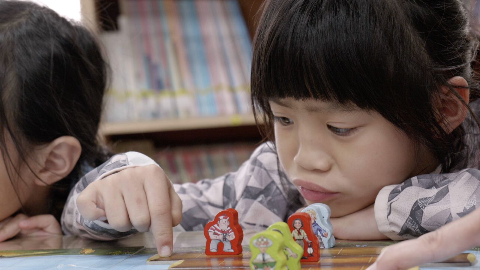 山上的特別課 女孩趴在桌上看著同伴移動桌遊人偶