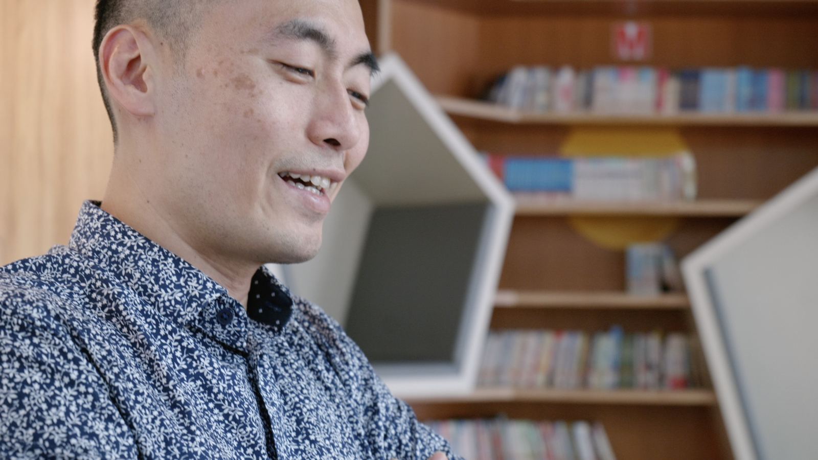 山上的特別課 老師在書架前看著孩子微笑