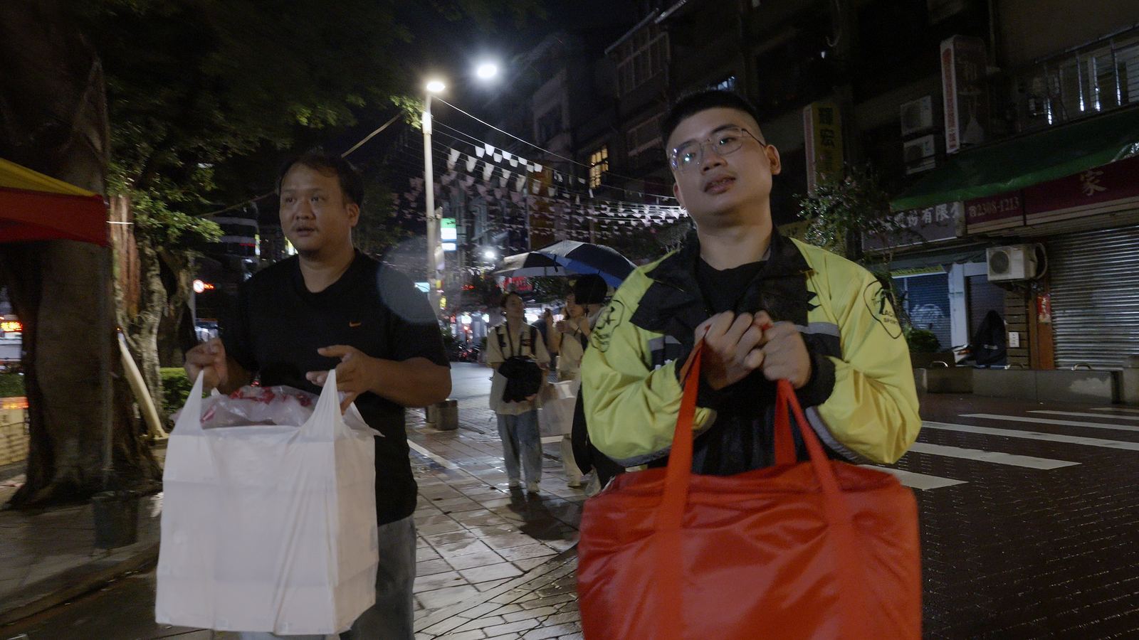尋找棲所 夜裡街頭兩名男子提著食物發送給無家者