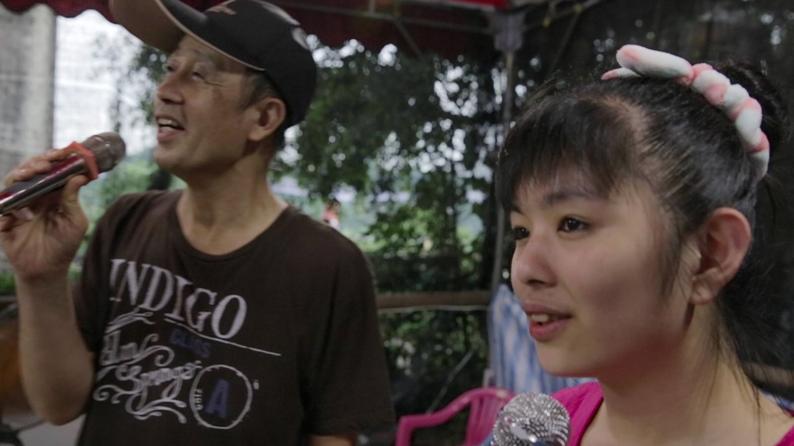溫度-傳導 戴帽爸爸拿著麥克風歌唱,身旁女兒在一旁聆聽