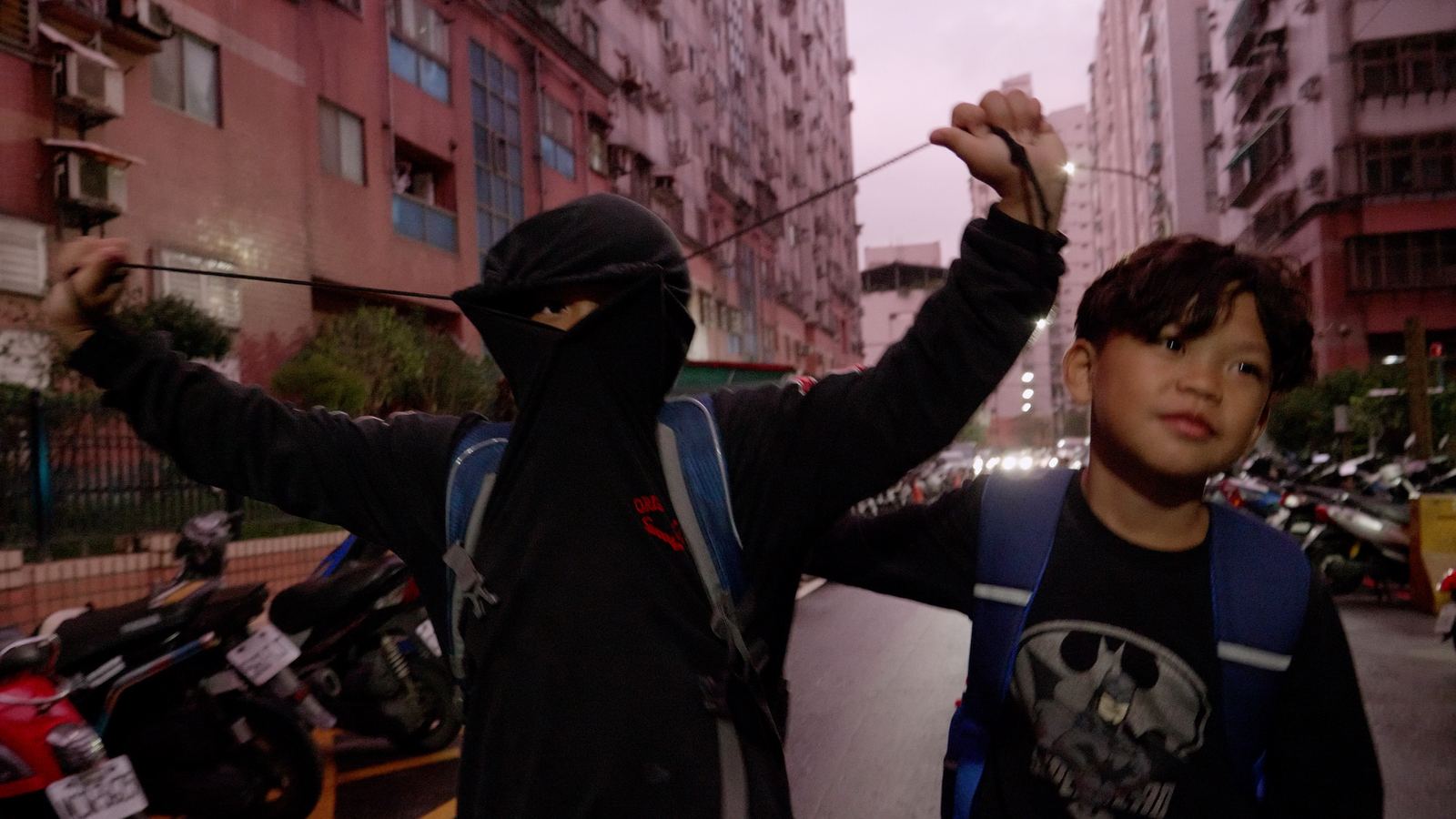 看見WAWA森林 放學路上蒙面的孩子與同伴在街邊嬉鬧