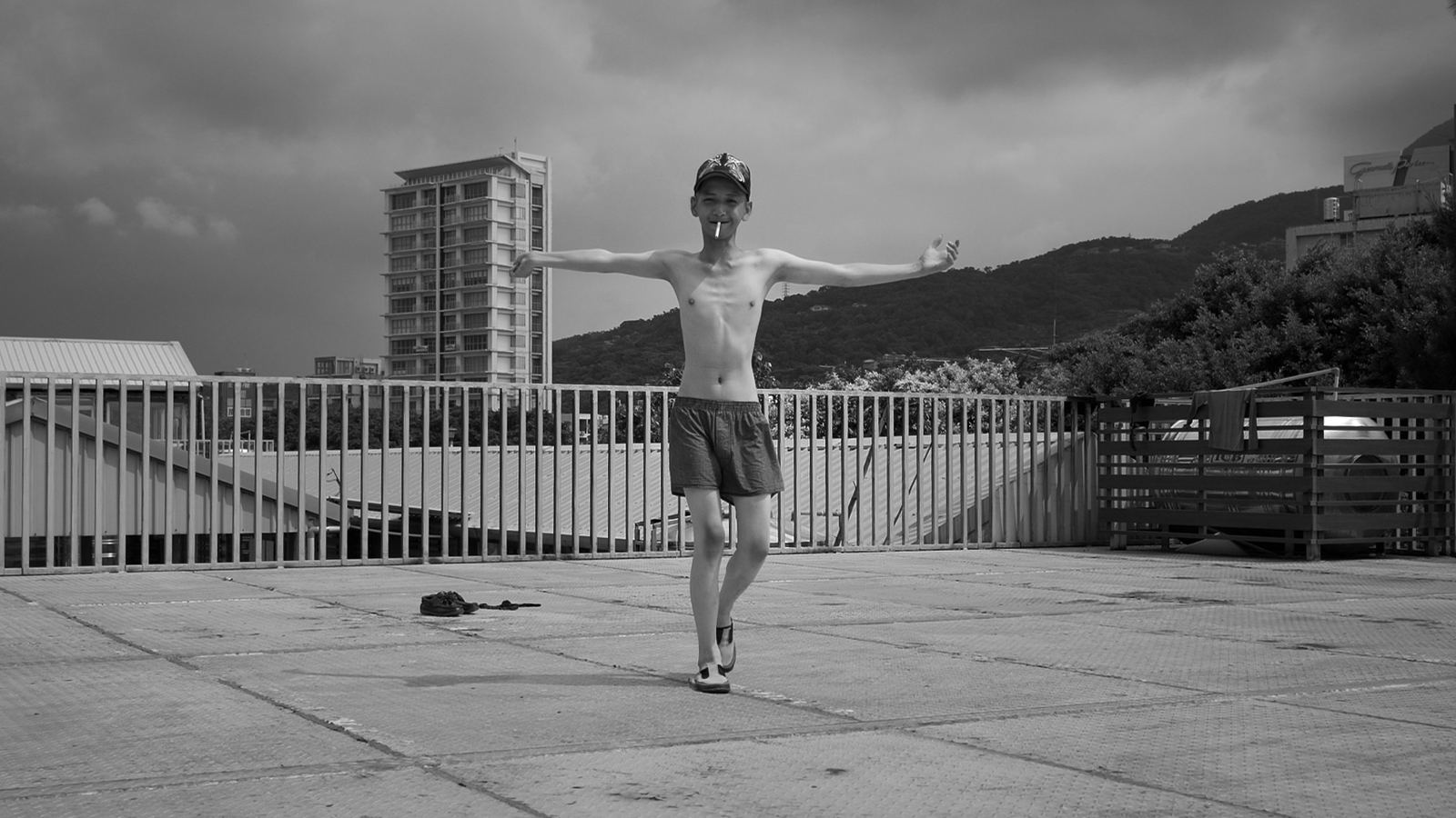 雲 少年赤裸上身張開雙臂走在空曠的天橋上